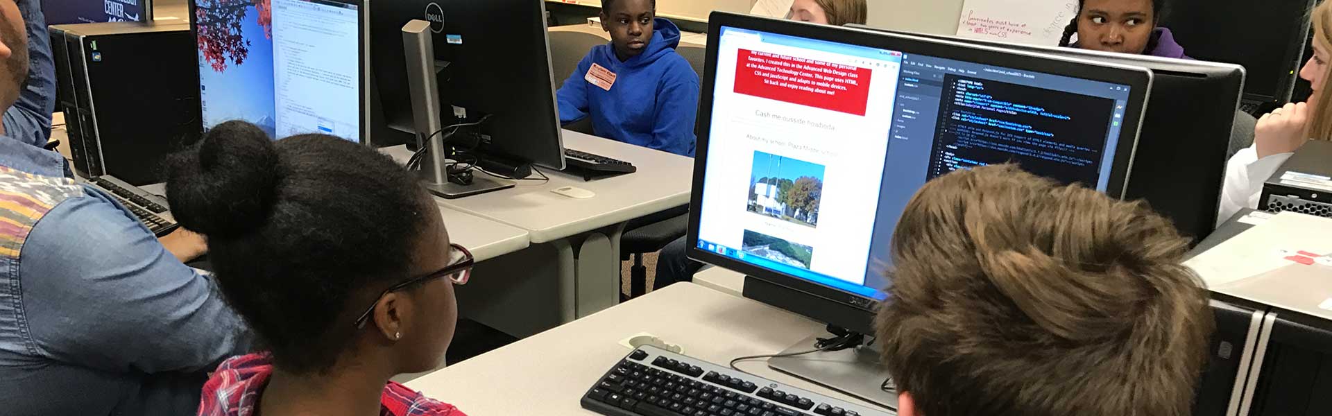 Two students looking at their website.